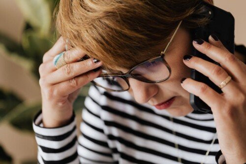 Anxious woman having phone conversation in office