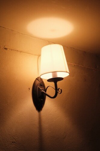 a wall light with a white shade on it